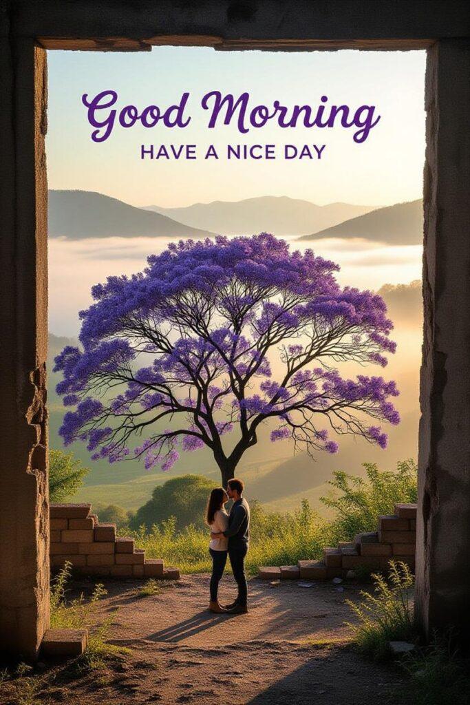 Beautiful love good morning image showing a romantic couple standing under a purple blooming tree at sunrise, with soft golden light, mountains in the background, and positive morning vibes.
